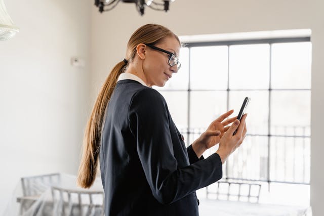 a property manager talking photos a unit on their phone